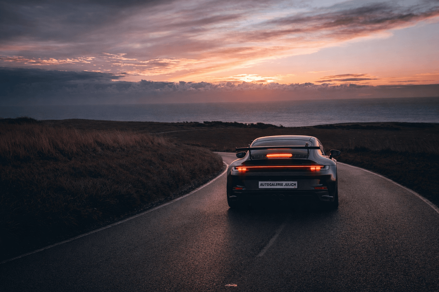Sportwagen auf einer Straße bei Sonnenuntergang